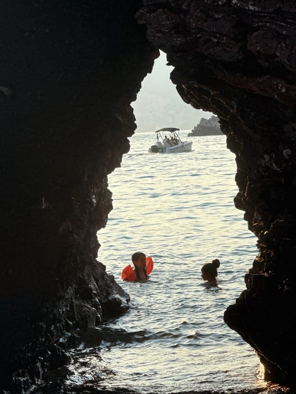 Cave openings, kayaks, and pebble beaches along the Budva coast