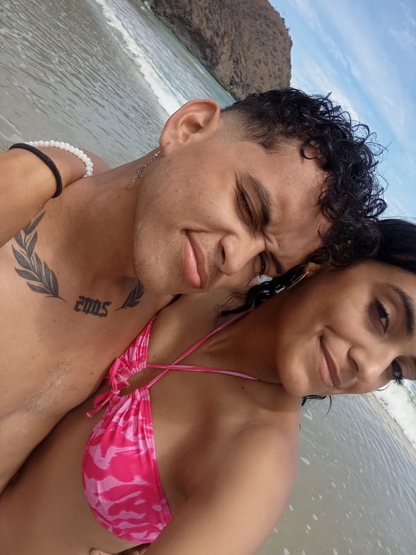 Woman plays with dog at Venezuelan beach under cloudy skies