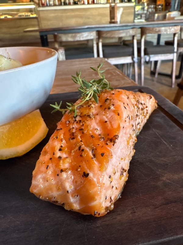 Diner documents salmon meal at Kuta restaurant