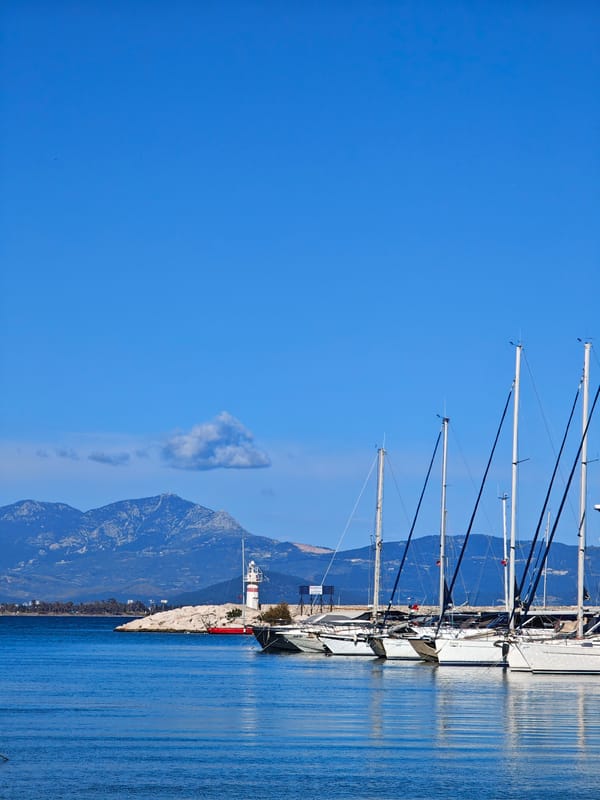 Sailboats docked at Finike marina under clear skies