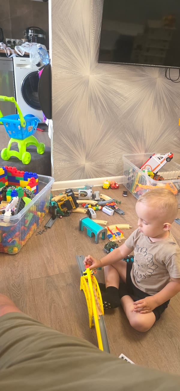 Playroom scene in Berdsk with toy train track and organized bins