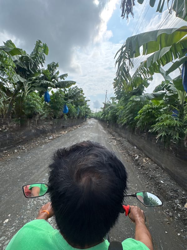 Motorcyclist travels rural dirt road in Carmen, Philippines