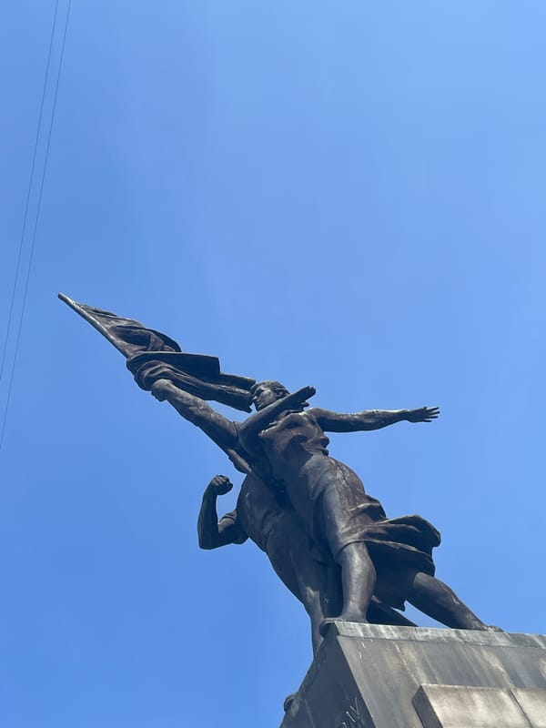 Bronze statue with raised arm photographed in Yekaterinburg