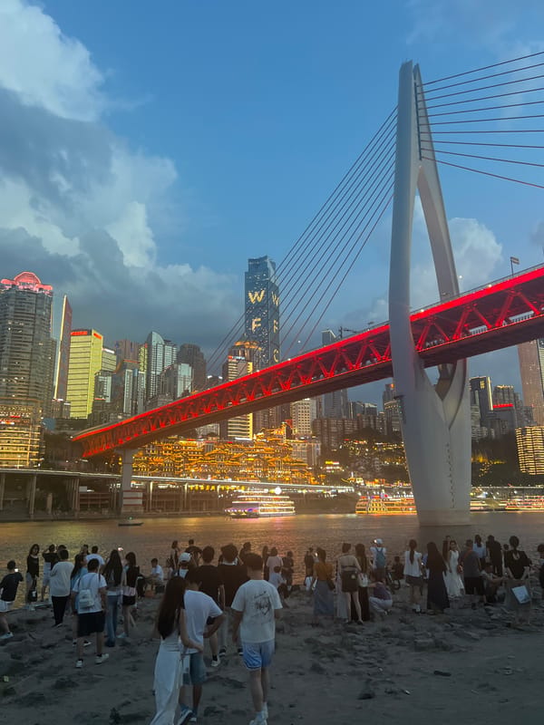 Chongqing's red-lit bridge and riverfront at dusk