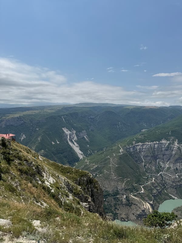 Green canyon and winding road cut through Russian wilderness