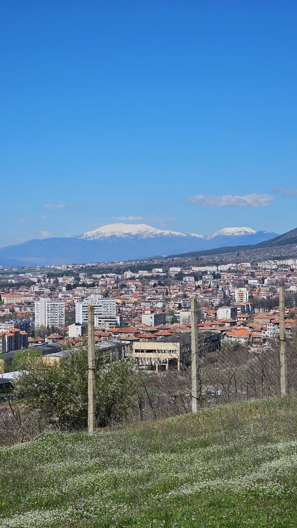 Aerial view captures Karlovo cityscape against snow-capped mountains