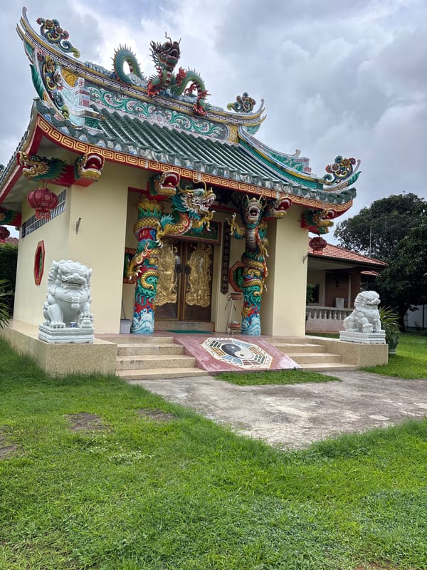 Riding past ornate Chinese temples through Chalong's palm-lined streets