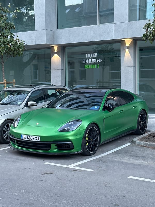 Green Porsche parked outside modern building in Varna, Bulgaria