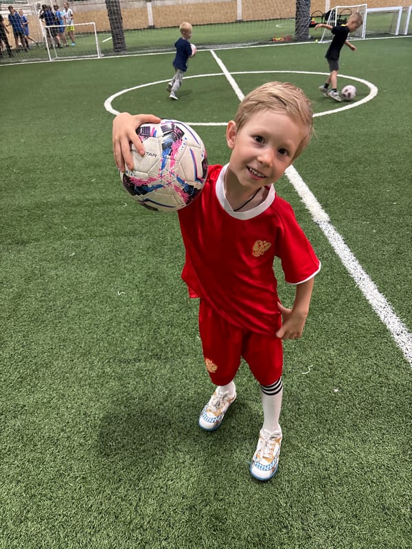 Young boy poses with soccer ball on indoor field