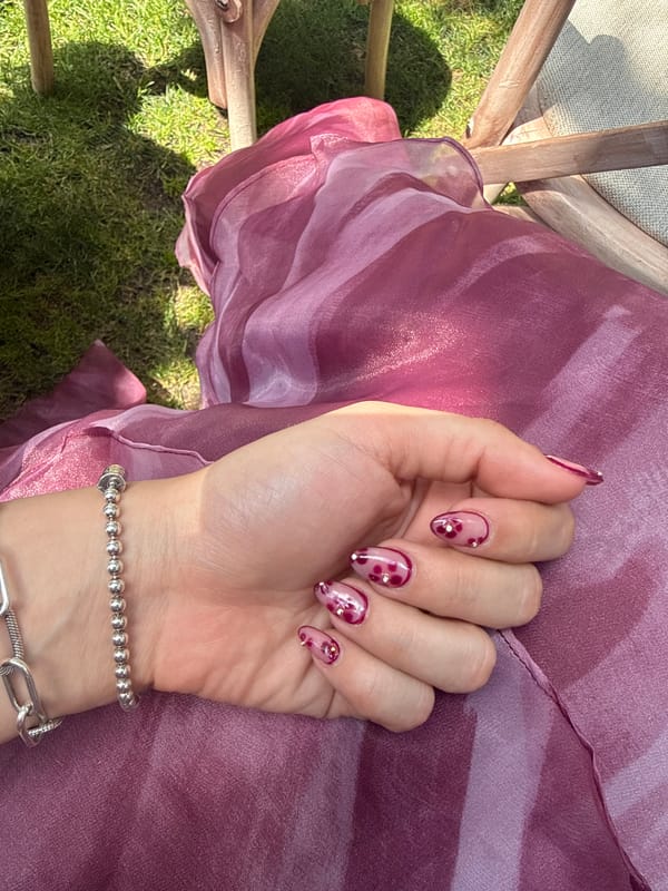 Hand with decorated nails rests on fabric in Querétaro