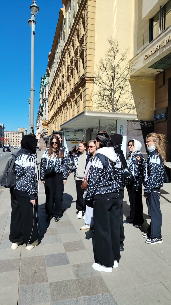 Eight people in musical jackets gather on city sidewalk