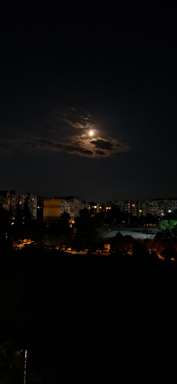 Quiet Sofia night: moon, streetlights, and a stairwell window
