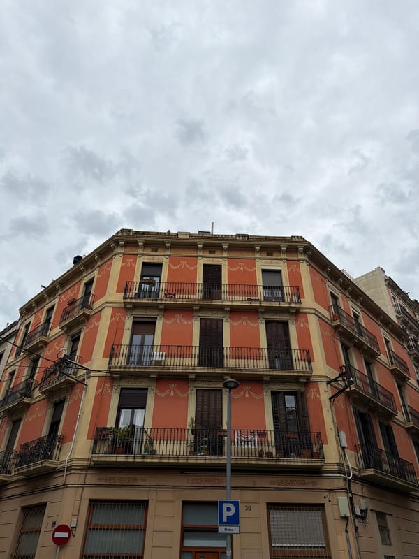 Terracotta building with cream stripes observed in Barcelona