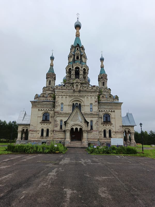 Ornate Orthodox church with domes and bell towers under gray skies