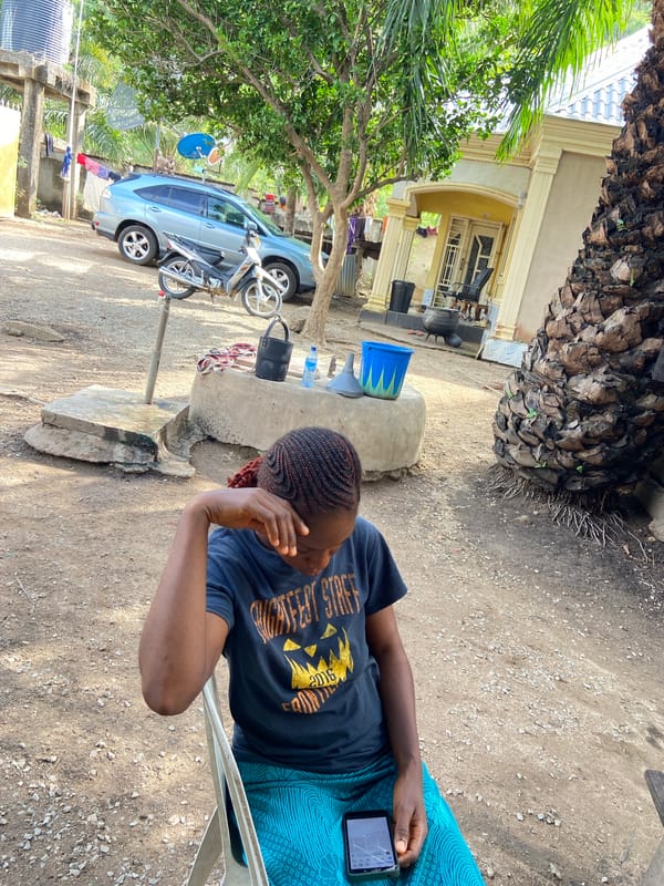 Woman sits outside home in Mararaba, Nigeria