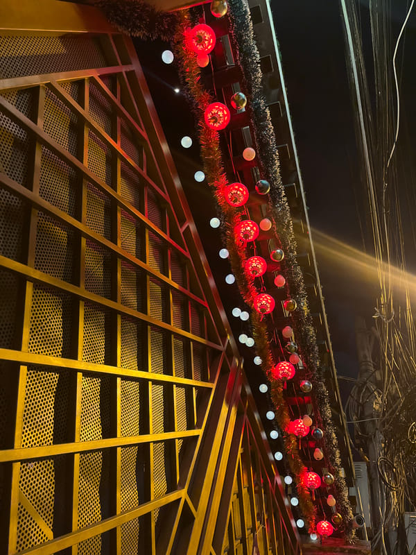 Vietnamese street at night, festive lights and temple details