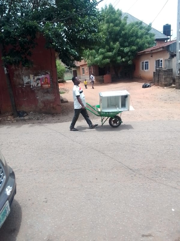 Residents transport goods by wheelbarrow through Onitsha streets