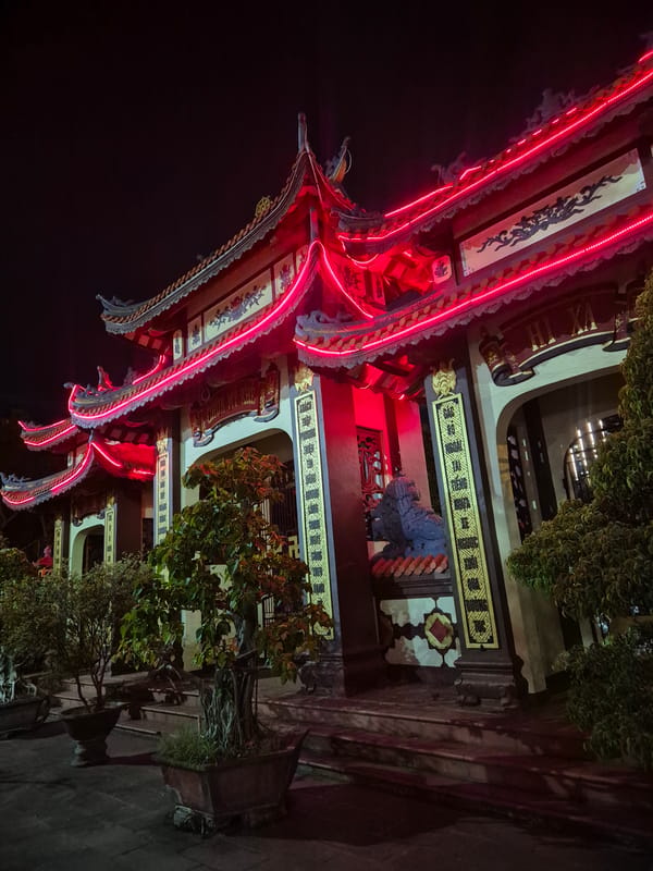Nighttime temple complex in Đà Nẵng lit up with neon and lanterns