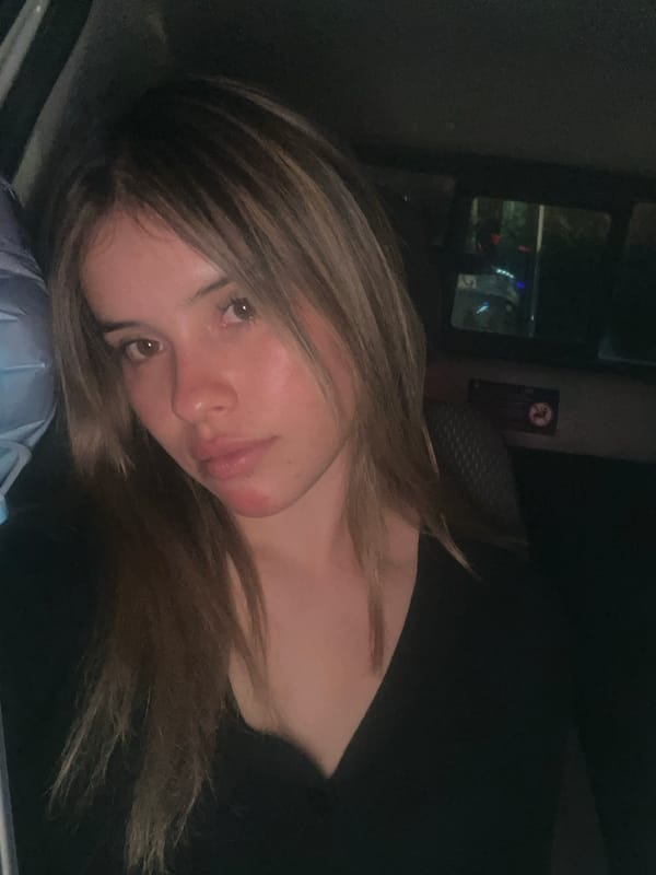 Woman rests with birthday balloon in car backseat