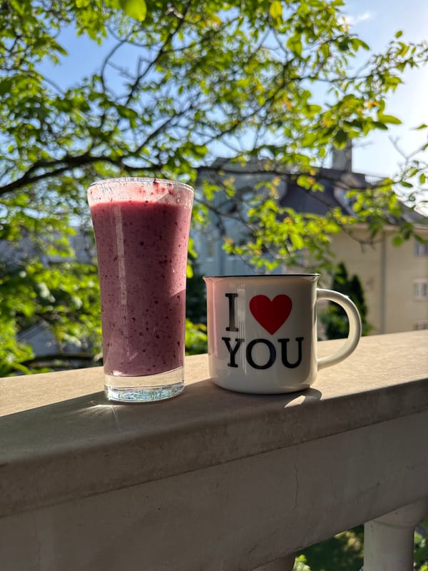 Love mug and smoothie spotted on outdoor ledge