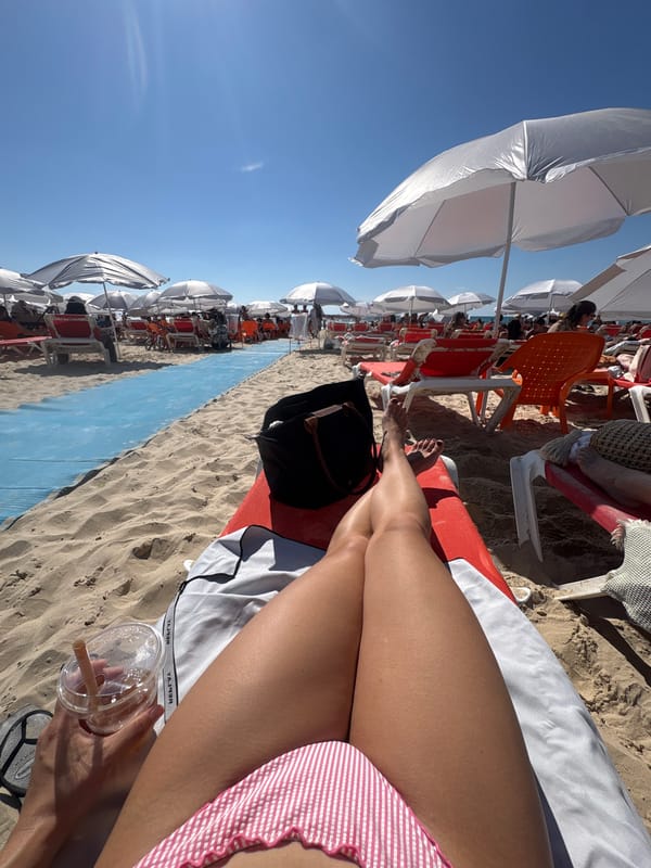 Beachgoer enjoys drink while sunbathing in Tel Aviv