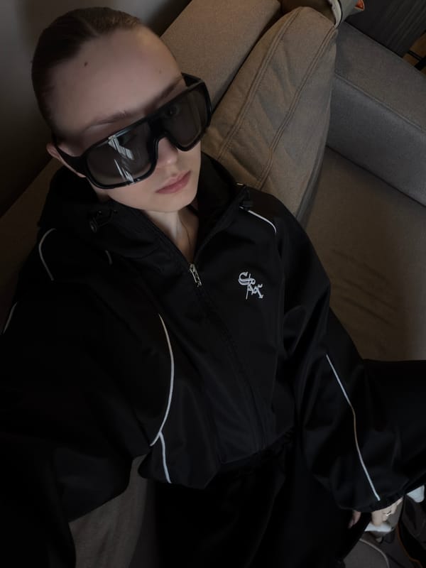 Person in black tracksuit rests on sofa in Moscow