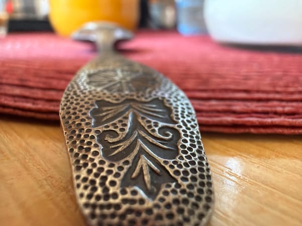 Ornate silver object photographed on pink fabric in Velingrad