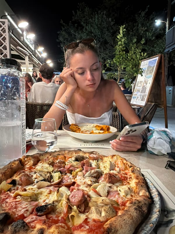 Pizza and phone time at a Greek restaurant terrace