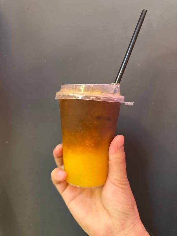Customer enjoys layered drink at Dolgoprudny cafe