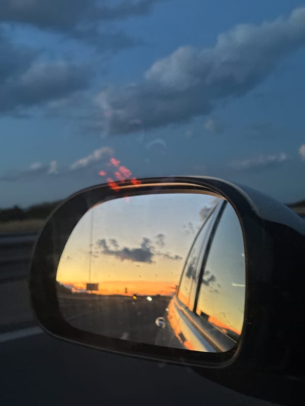 Highway sunset reflected in rearview mirror near Belozem