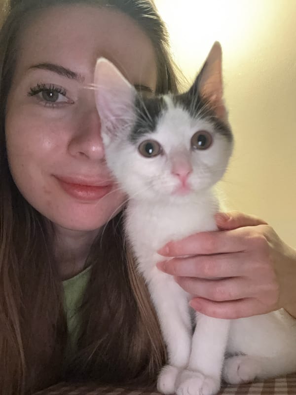 Woman poses with kitten in sideways portrait in Łódź