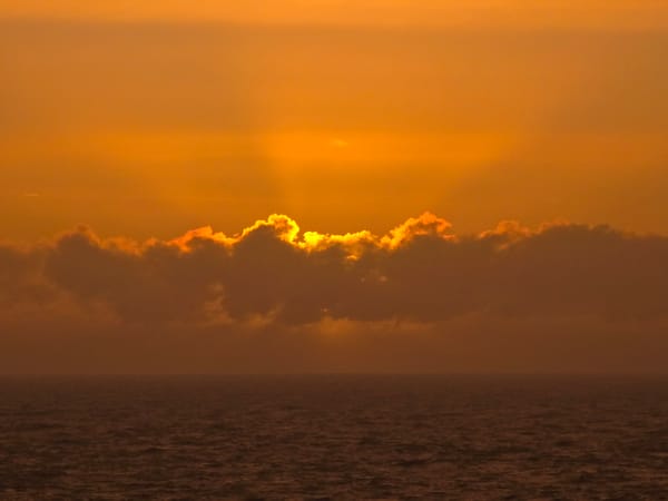 Sunset documented over North Sea waters with oil rig visible