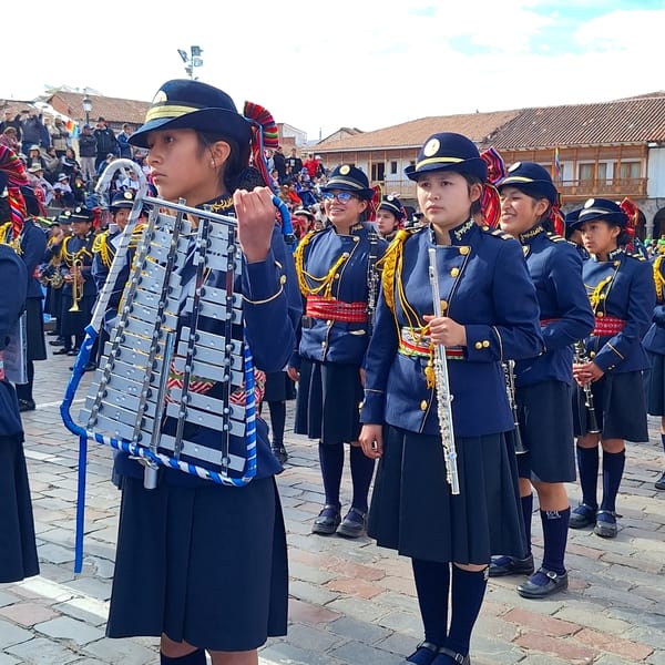 Youth marching band parades through historic Cuzco streets