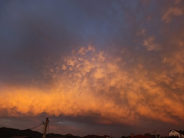 Vivid sunset sky over residential rooftops at dusk