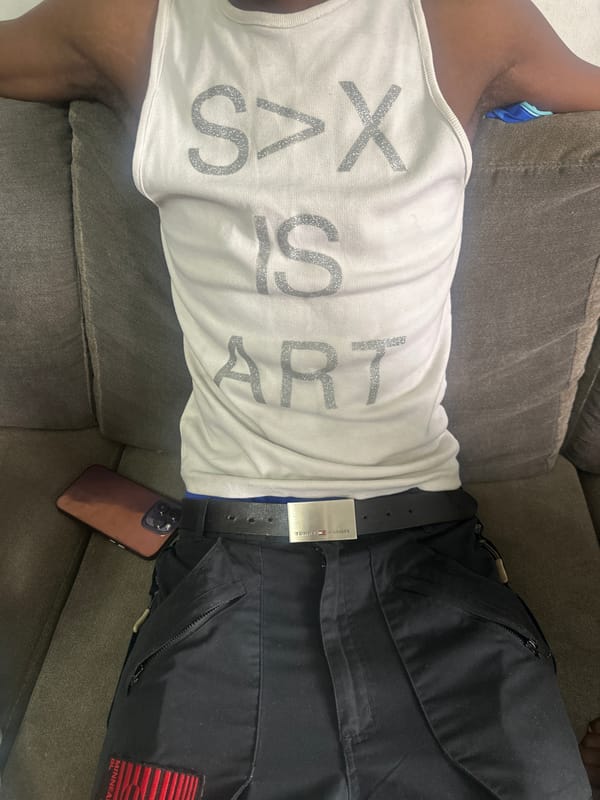 Person photographed relaxing on couch in Abuja with art-themed shirt