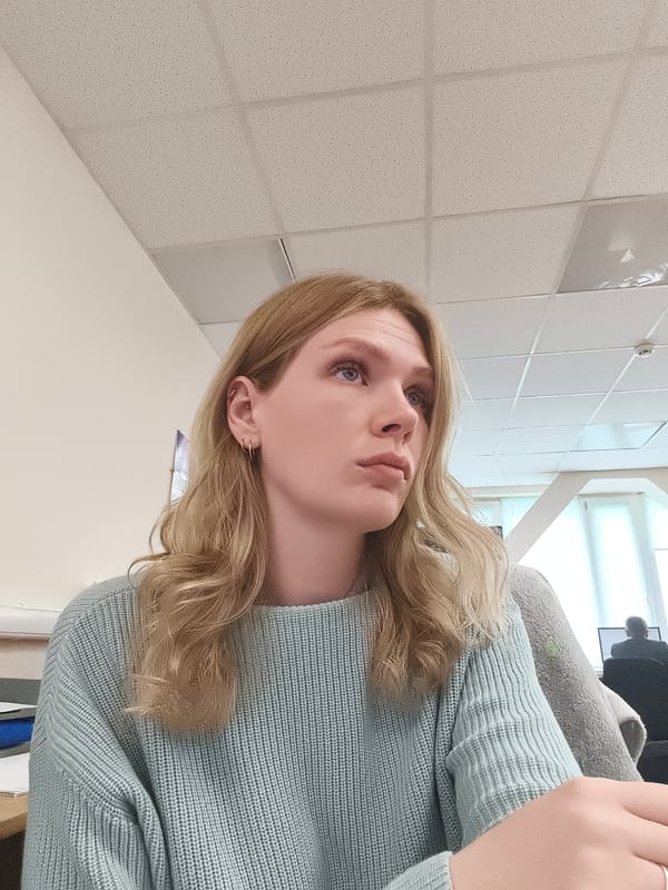 Woman in blue sweater observed at desk looking upward