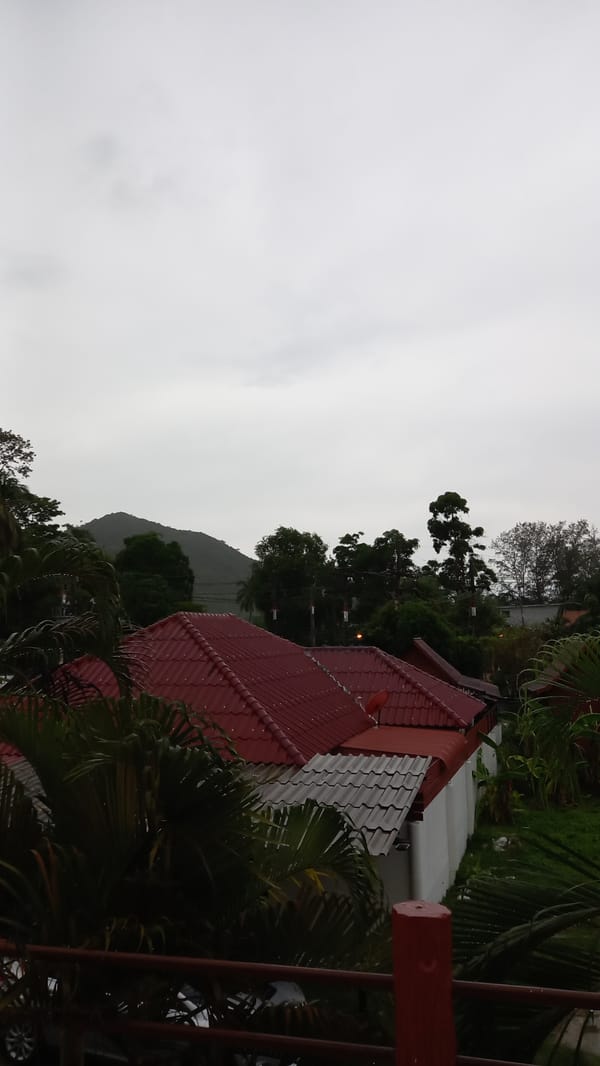 Heavy rain and mist roll over Ko Pha-ngan from a balcony view