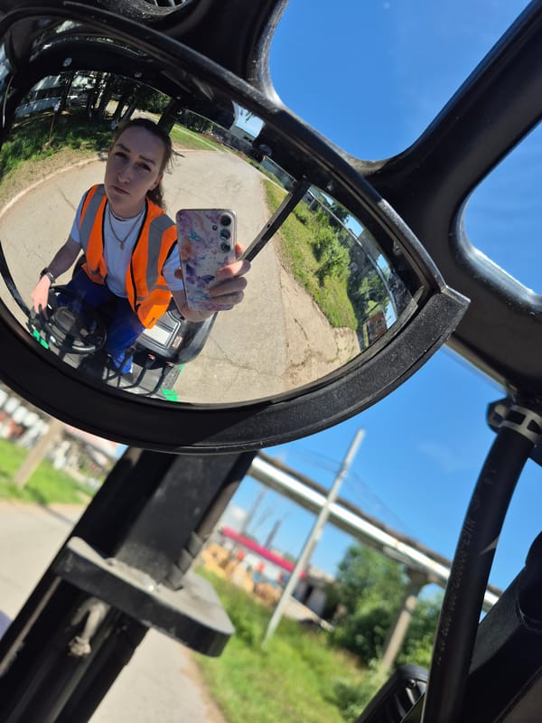 Mirror selfies in orange vests at a Chaikovsky work site