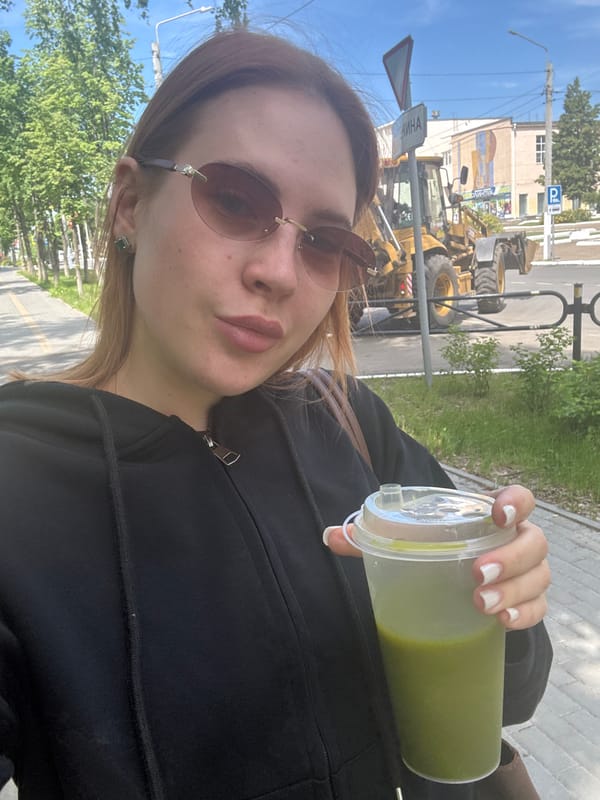 Woman takes selfies, walks with drink in Chaikovsky