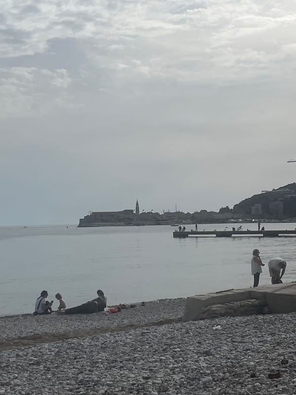 Budva waterfront scene captured showing pebble beach, Adriatic coastline