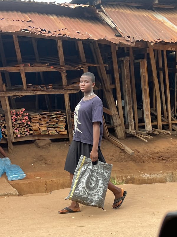 Daily life captured in Obosi market area, elderly woman walking