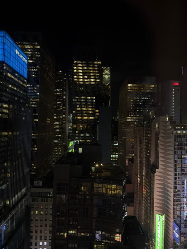 Nighttime aerial view captures illuminated NYC high-rises