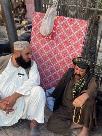 Two men sit outdoors in Quetta, Pakistan