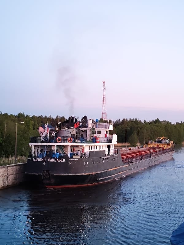 Cargo ships transit Russian waterways near Devyatiny at twilight
