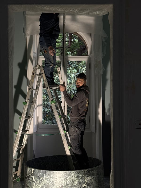 Two workers on ladder during renovations in Erba