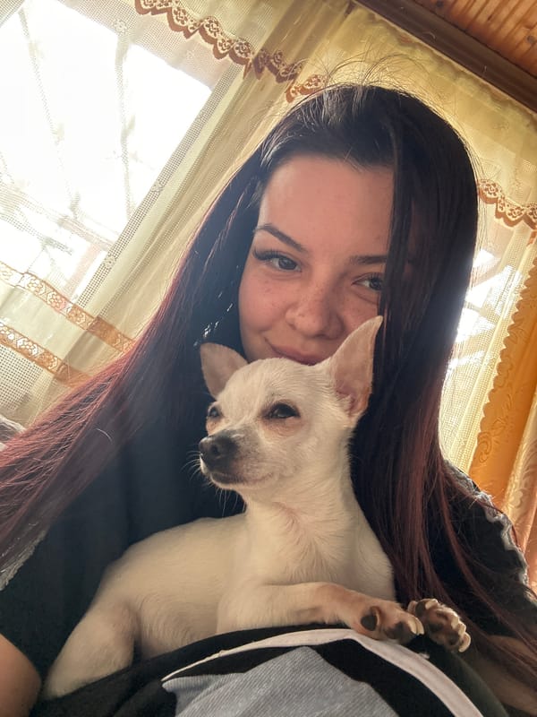 Woman poses with white Chihuahua in Bulgarian home