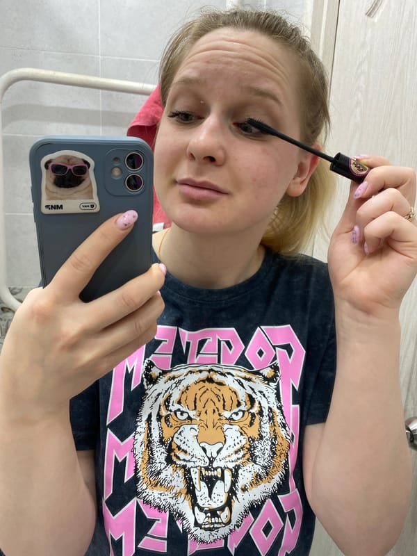 Woman documents makeup routine via bathroom selfie in Chaikovsky