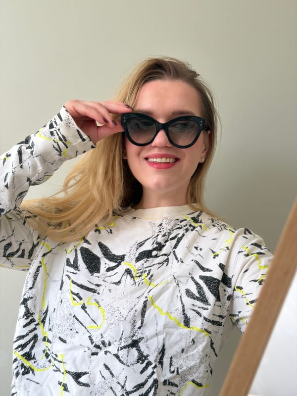 Woman takes selfies with teddy bear under cloudy Latvian skies