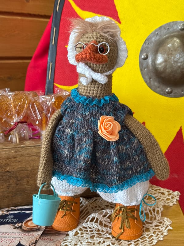 Handcrafted dolls and wooden toys displayed on wooden surfaces