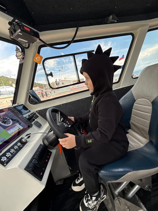 Child steers boat during morning Lake Baikal outing